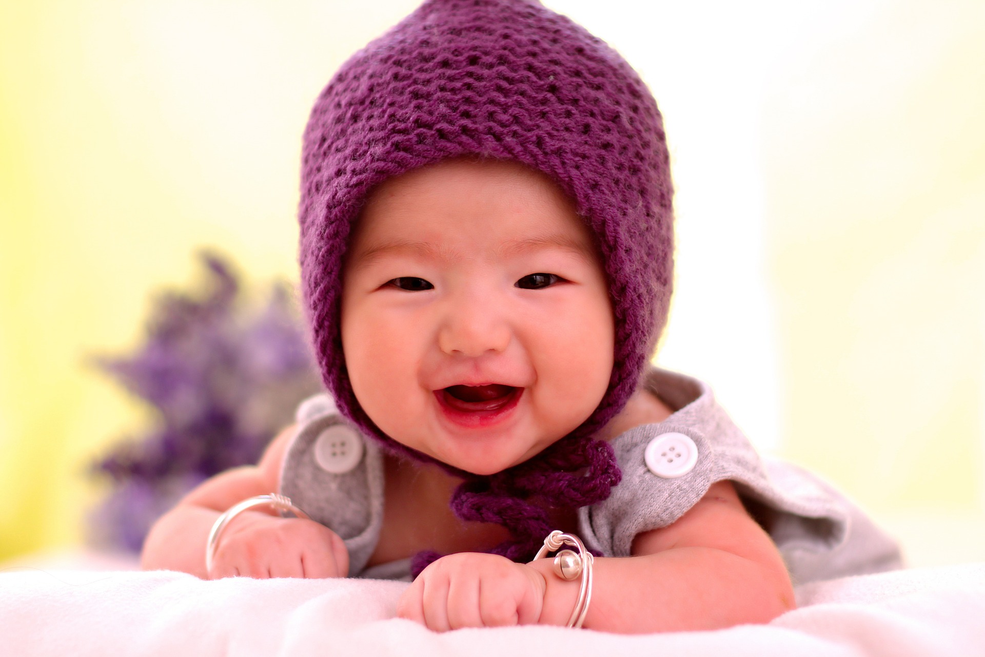 Visage d'un bébé souriant portant un bonnet violet